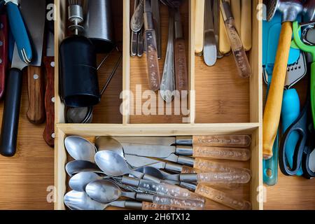 Bac à couverts dans le tiroir de la table de cuisine, avec compartiments. Banque D'Images