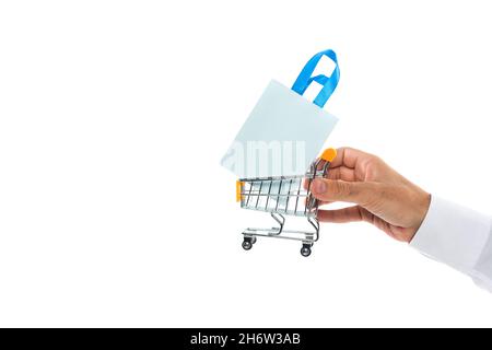vue rognée d'un homme tenant un petit panier avec sac en papier isolé sur le blanc Banque D'Images