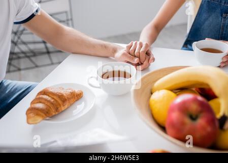 vue courte d'un couple tenant les mains pendant le petit déjeuner Banque D'Images