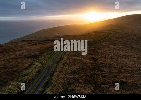 Coucher de soleil en soirée sur une ruelle de campagne tranquille près de Portmagee, comté de Kerry, Irlande Banque D'Images