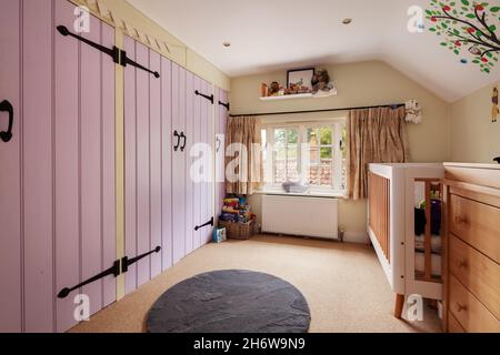 Hargrave, Suffolk, Angleterre - juin 10 2020 : Chambre traditionnelle de campagne anglaise.Chambre pastel rose pour enfants avec décoration berceau et plafond. Banque D'Images