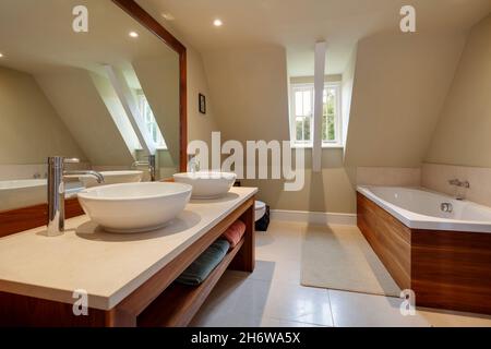 Wimbish, Angleterre - juillet 30 2019: Salle de bains dans la maison établie décorée simplement avec baignoire deux lavabos et toilettes Banque D'Images