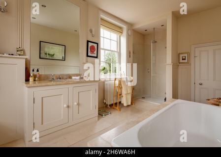 Wimbish, Angleterre - juillet 30 2019: Salle de bains dans la maison de campagne anglaise établie avec des murs lambrissés en partie, lavabo, douche et baignoire Banque D'Images