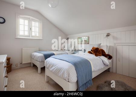 Calford Green, Suffolk, Angleterre - janvier 17 2020: Chambre loft avec mansardée lits jumeaux et placard de rangement pour les avant-bras. Banque D'Images