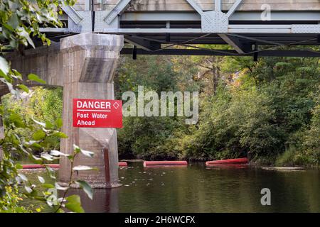 Un panneau de danger rouge sur le montant du pont indique que l'eau est en avance rapidement.Bouées rouges dans la rivière pour empêcher les plaisanciers de pénétrer dans les rapides. Banque D'Images