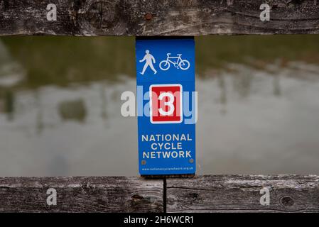 Cornwall, Angleterre, Royaume-Uni.2021. Signe de marqueur du réseau national de cycle sur une clôture au-dessus d'une rivière. Banque D'Images