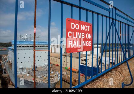 Cornwall, Angleterre, Royaume-Uni.2021. Ne montez pas sur le panneau de rambardes d'une clôture métallique peinte en bleu surplombant une zone industrielle. Banque D'Images