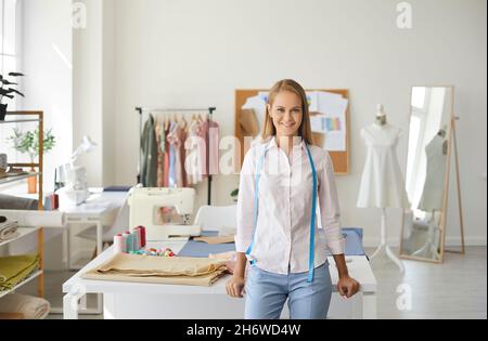 Portrait d'une jeune femme souriante qui travaille comme couturière debout dans son studio Banque D'Images