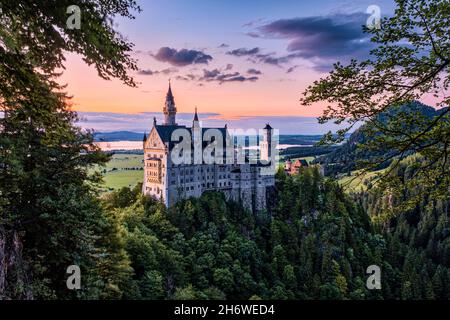 Vue panoramique sur le château de Neuschwanstein au coucher du soleil. Banque D'Images