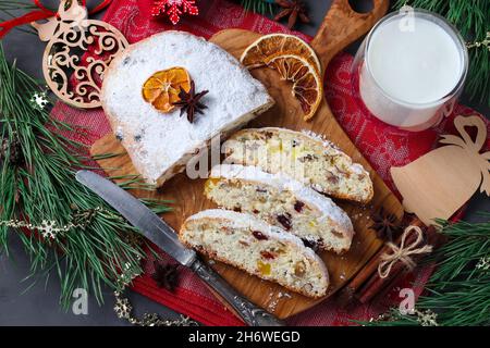 Tranche de Noël savoureux stollen avec des fruits secs et un verre de lait.Gâteries traditionnelles allemandes.Gros plan Banque D'Images