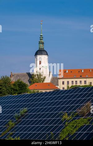 Panneaux solaires Photovoltaik disposés sur la pente d'une colline en face de la petite ville médiévale. Banque D'Images