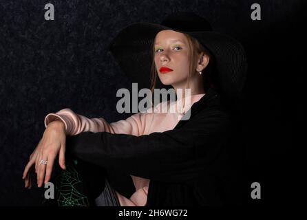 Une adolescente vêtue d'un chapeau noir pour les fêtes d'halloween. Banque D'Images