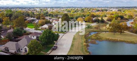 Vue aérienne sur le lac et Parkside quartier résidentiel du centre-ville de Dallas en arrière-plan lointain.Maisons unifamiliales typiques avec arbres mûrs bri Banque D'Images