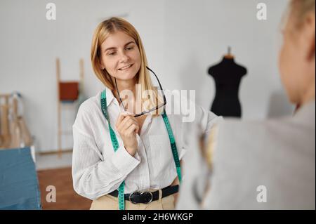 Couturière prend des mesures de femme, atelier Banque D'Images