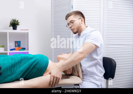 Thérapeute ostéopathie travaillant massage sportif avec les épaules de la femme athlète. Banque D'Images