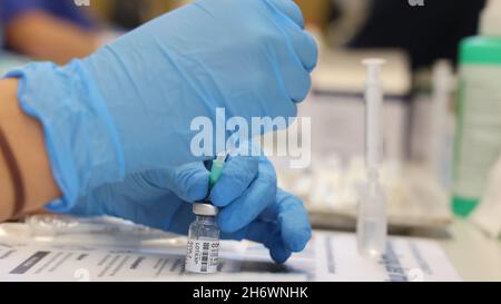 Kahla, Allemagne.18 novembre 2021.Un travailleur médical tire le vaccin de Biontech dans une seringue dans le gymnase d'une école.Ici, l'Association des médecins légaux d'assurance maladie de Thuringe réalise la vaccination mobile.Credit: Bodo Schackow/dpa-Zentralbild/dpa/Alay Live News Banque D'Images