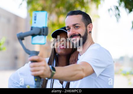 deux amis de différentes ethnies prenant un selfie avec le mobile Banque D'Images