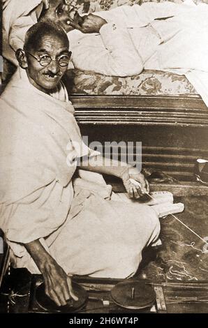 Un portrait informel de Mahatma Gandhi en 1931 avec sa machine à tourner.(Mohandas Karamchand Gandhi ( 1869 – 1948)/ Ghandhi a insisté sur le fait que l'homme et non les machines devraient être le maître, bien qu'il ait vu les machines à tourner comme le moyen spirituel de faire de l'Inde et de la nation industrielle. Banque D'Images