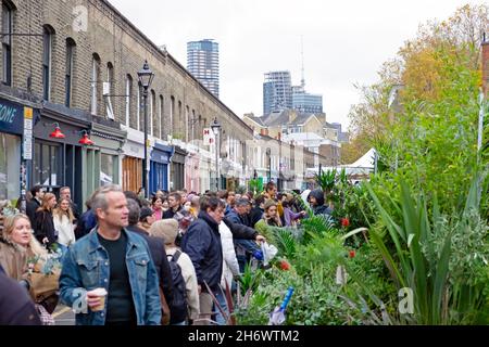 Marché aux fleurs de Columbia Road les gens achetant des plantes fleurs dans la rue aux stands du marché le dimanche en novembre 2021 East London UK KATHY DEWITT Banque D'Images