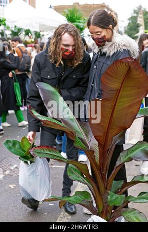 Columbia Road Flower Market gens achetant des plantes fleurs portant des masques faciaux covid dans la rue en novembre 2021 East London UK KATHY DEWITT Banque D'Images