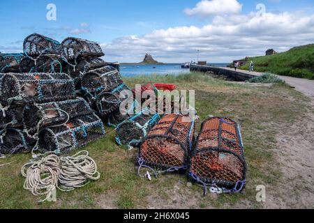 Port de Lindisfarne avec pots de crabe et de homard et château de Lindisfarne en arrière-plan.Ile Sainte Royaume-Uni. Banque D'Images