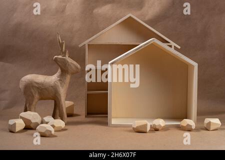 Concept de Noël écologique minimal.Maison et cerf en bois et papier.Décoration de Noël bio durable à faire soi-même. Banque D'Images