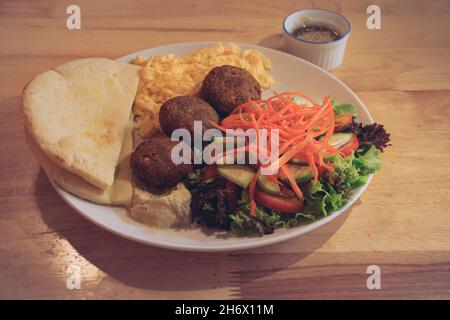 Pain pita, falafel, houmous, salade et œufs brouillés pour un petit déjeuner moderne et sain du Moyen-Orient Banque D'Images