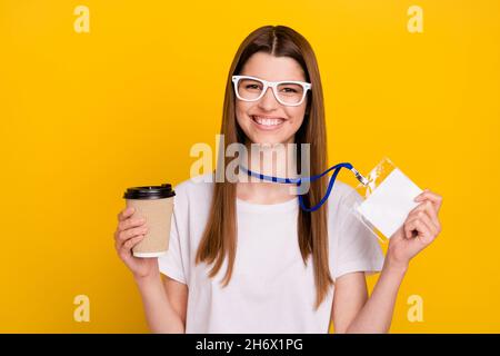 Photo de jeune gai heureux positif femme bonne humeur tenir le nom du café étiquette isolée sur fond jaune Banque D'Images