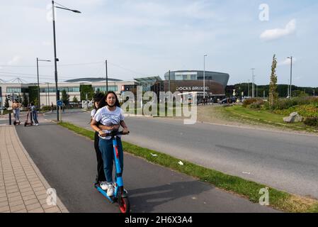 Laeken, région de Bruxelles-capitale, Belgique, Bruxelles - 09 24 2021 : deux adolescentes turques conduisant une marche électrique sur le site de Docks Banque D'Images