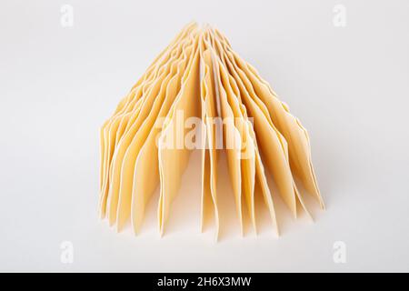 Lasagnes crues.Feuilles de pâte sèches pour lasagnes sur fond blanc.Cuisine italienne. Banque D'Images