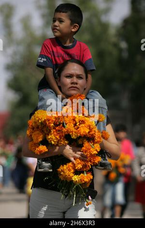 Offrant des marigolds jaune-orange, appelés cempasuchil, le jour des morts ou le jour de la mort.Aussi connu sous le nom de «Flor de Meurto», fleur des morts, ces fleurs sont pensées pour attirer les âmes des morts aux offrandes.Cette fête, qui honore les morts, est célébrée principalement au Mexique et par des personnes d'origine mexicaine, et coïncide avec les jours saints catholiques de la Toussaint et de la Journée des âmes.San Luis Potosi, Mexique.2 novembre 2007. Banque D'Images