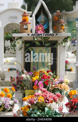 Offrant des marigolds jaune-orange, appelés cempasuchil, le jour des morts ou le jour de la mort.Aussi connu sous le nom de «Flor de Meurto», fleur des morts, ces fleurs sont pensées pour attirer les âmes des morts aux offrandes.Cette fête, qui honore les morts, est célébrée principalement au Mexique et par des personnes d'origine mexicaine, et coïncide avec les jours saints catholiques de la Toussaint et de la Journée des âmes.San Luis Potosi, Mexique.2 novembre 2007. Banque D'Images