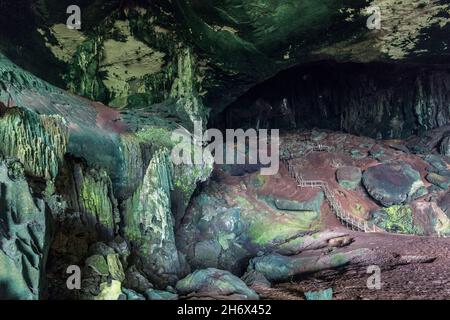 Sentier de promenade et rochers couverts d'algues à l'entrée de la grotte de Niah, en Malaisie Banque D'Images