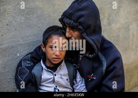 Gaza, Gaza.18 novembre 2021.Le père et le fils palestiniens proches de Sami al-Amour pleurent dans le camp de Deir al-Balah dans le centre de la bande de Gaza.Sami al-Amour, 39 ans, résident de la ville de Deir al-Balah dans la bande de Gaza, est décédé dans sa cellule ce matin par négligence médicale délibérée.Il a été arrêté par l'occupation israélienne en 2008 et condamné à 19 ans de prison.Crédit : SOPA Images Limited/Alamy Live News Banque D'Images