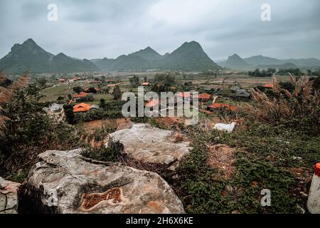 Vue panoramique sur la chèvre de montagne sur une falaise surplombant les montagnes brumeuses de la vallée de Bac son dans le district de Lang son Vietnam Banque D'Images