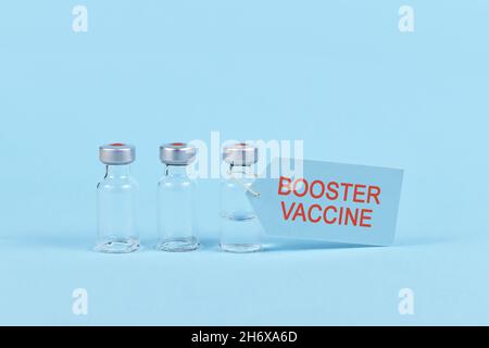 Vaccin de rappel du virus Corina concept avec flacon et seringue sur fond bleu Banque D'Images