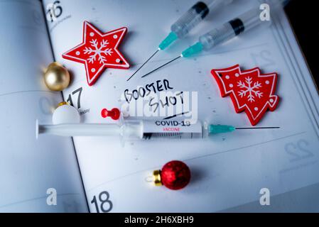 Concept de réservation de doses de rappel et de jab de vaccin Covid.Trois seringues sur le calendrier avec des décorations de Noël comme un concept pour le 3ème vaccin Covid-19 font Banque D'Images