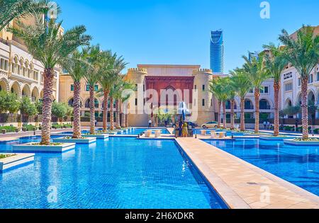 DUBAÏ, Émirats Arabes Unis - 3 MARS 2020 : l'allée étroite entre les piscines menant à l'immense statue du cheval et la réplique de la porte médiévale dans la vieille ville de l'île com Banque D'Images