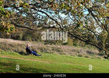 Un couple âgé s'est assis et a profité du temps ensoleillé de l'automne à Newlands Corner dans les collines de Surrey, près de Guildford, en Angleterre, au Royaume-Uni Banque D'Images