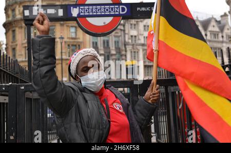 Londres, Royaume-Uni.18 novembre 2021.Un manifestant détient un drapeau ougandais face à la Maison de l'Ouganda, à Trafalgar Square pendant la manifestation.les Ougandais du Royaume-Uni ont organisé une manifestation au Haut-commissariat de l'Ouganda à Londres et ont appelé le gouvernement britannique à s'élever contre la détention d'activistes politiques et les violations des droits de l'homme.Crédit : SOPA Images Limited/Alamy Live News Banque D'Images