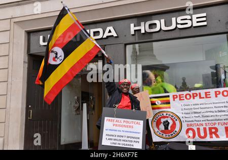 Londres, Royaume-Uni.18 novembre 2021.Un manifestant fait monter un drapeau ougandais en face de la Maison de l'Ouganda, à Trafalgar Square pendant la manifestation.les Ougandais du Royaume-Uni ont organisé une manifestation au Haut-commissariat de l'Ouganda à Londres et ont appelé le gouvernement britannique à s'élever contre la détention d'activistes politiques et les violations des droits de l'homme.Crédit : SOPA Images Limited/Alamy Live News Banque D'Images