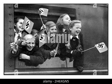 WW2 ALLEMAGNE NAZIE EVACUATION DES ENFANTS KINDERTRANSPORTE KINDERLANDVERSCHICKUNG WW2 années 1940 Evacuations des enfants en Allemagne pendant la Seconde Guerre mondiale les enfants allemands quittent Berlin dans un train spécial 'Kindertransporte' qui agite les drapeaux nazis de la swastika tous les jours les nouveaux enfants de toutes les régions de la capitale de Reich dans le cadre de la terreDéportation dans d'autres districts du Reich allemand nazi, pour les protéger contre les bombardements alliés DES ENFANTS ALLEMANDS WW2 Kinder transport Vintage WW2 Allemagne nazie ' Kinderlandverschichung ' Poster de propagande de 1942-1943.Bombardements alliés des villes allemandes Banque D'Images