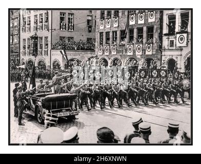 ADOLF HITLER NUREMBERG CITY RALLY 1935 sa UNIFORME dans son automobile Mercedes haut ouvert salue sa Sturmabteilung troupes holding DEUTSCHLAND ERWACHE 'Germany awake ' swastika bannières sur un passé de mars à Nuremberg Allemagne 1935: Drapeaux et décorer les bannières les fenêtres avec des foules donnant Heil Hitler salue l'Allemagne nazie des années 1930 Banque D'Images