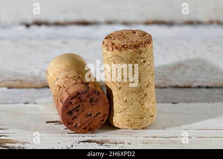 Deux bouchons en liège provenant de bouteilles de vin rouge se trouvent à la surface de la table blanche. Banque D'Images