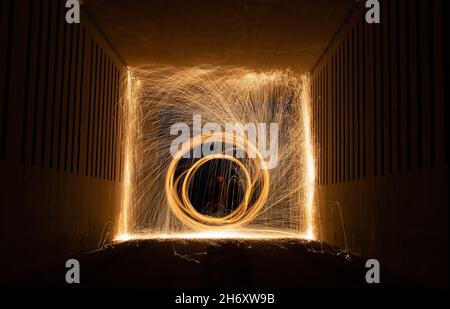 Peinture légère à la laine d'acier sur le feu tourbillonnant dans un tunnel souterrain dans l'obscurité la nuit, Écosse, Royaume-Uni Banque D'Images