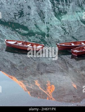 Paysage pittoresque avec le célèbre lac de Braies en automne Dolomites montagnes.Bateaux en bois dans les eaux claires du Lago di Braies, Alpes Dolomites, Italie.Pic lumineux de la montagne Seekofel dans l'eau Banque D'Images