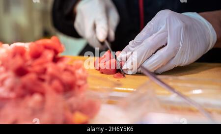 Vendeur cuisant des sushis de thon dans la rue du marché asiatique de poissons au Japon.Les gens ont préparé des fruits de mer populaires sur le célèbre marché de Tokyo.Délicieux plats japonais Banque D'Images