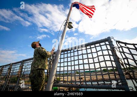 Porto Rico.9 novembre 2021.Le mécanicien de charpente de l'aviation de 2e classe Kaden Anderson hante l'enseigne pendant les couleurs du matin à bord du navire de combat littoral Freedom-variant USS Sioux City (LCS 11) alors que le navire est à Port Ponce, Porto Rico pour une disponibilité de maintenance planifiée (PMAV), 9 novembre 2021.Sioux City est déployée dans la zone d'opérations de la 4e flotte des États-Unis pour appuyer la mission de la Force opérationnelle interagences conjointe Sud, qui comprend des missions de lutte contre le trafic illicite de drogues dans les Caraïbes et le Pacifique oriental.Credit: U.S. Navy/ZUMA Press Wire Service/ZUMAPRESS.com/Alamy Live News Banque D'Images