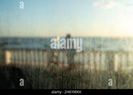 Salvador, Bahia, Brésil - 17 juin 2021 ; balustrade de la plage de Porto da Barra vue à travers le verre sale de l'arrêt de bus. Banque D'Images