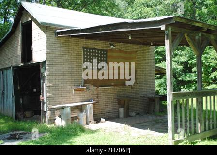 Le vieux drapeau américain en lambeaux est suspendu sur une petite Grange Banque D'Images